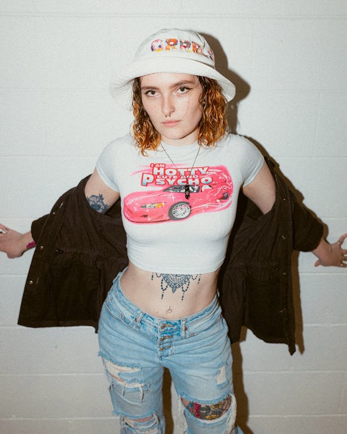 A woman in a white shirt and jeans with tattoos